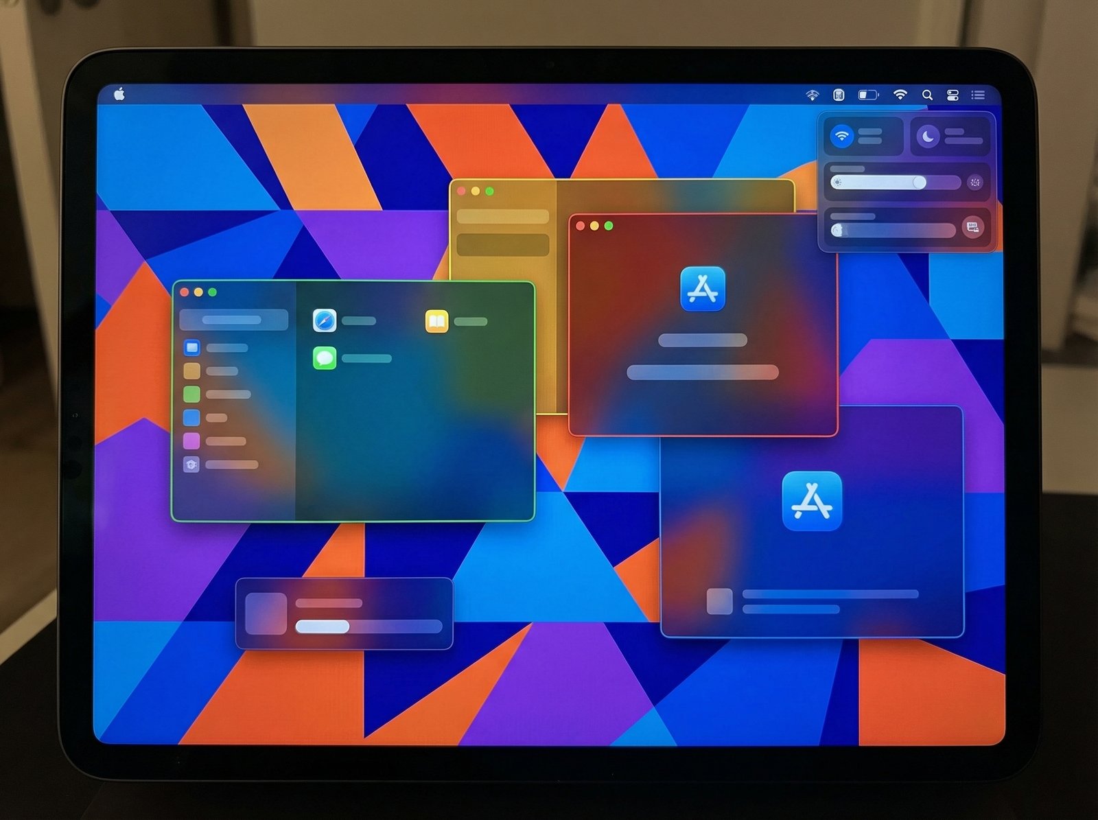 An iPad screen showing multiple freely resizable application windows overlapping, with a macOS-style Menu Bar visible at the top, illustrating advanced multitasking capabilities, productivity theme, modern layout, high contrast, colored geometric background, full frame, centered focus, no visible text, 4:3 aspect ratio, no Korean text.