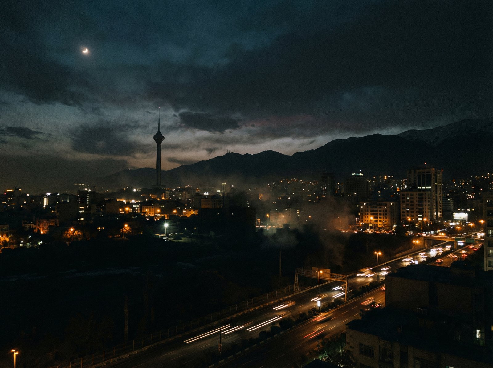 A cinematic night view of Tehran city skyline with dark shadows and mysterious atmosphere, high contrast, professional photography, no text, 4:3