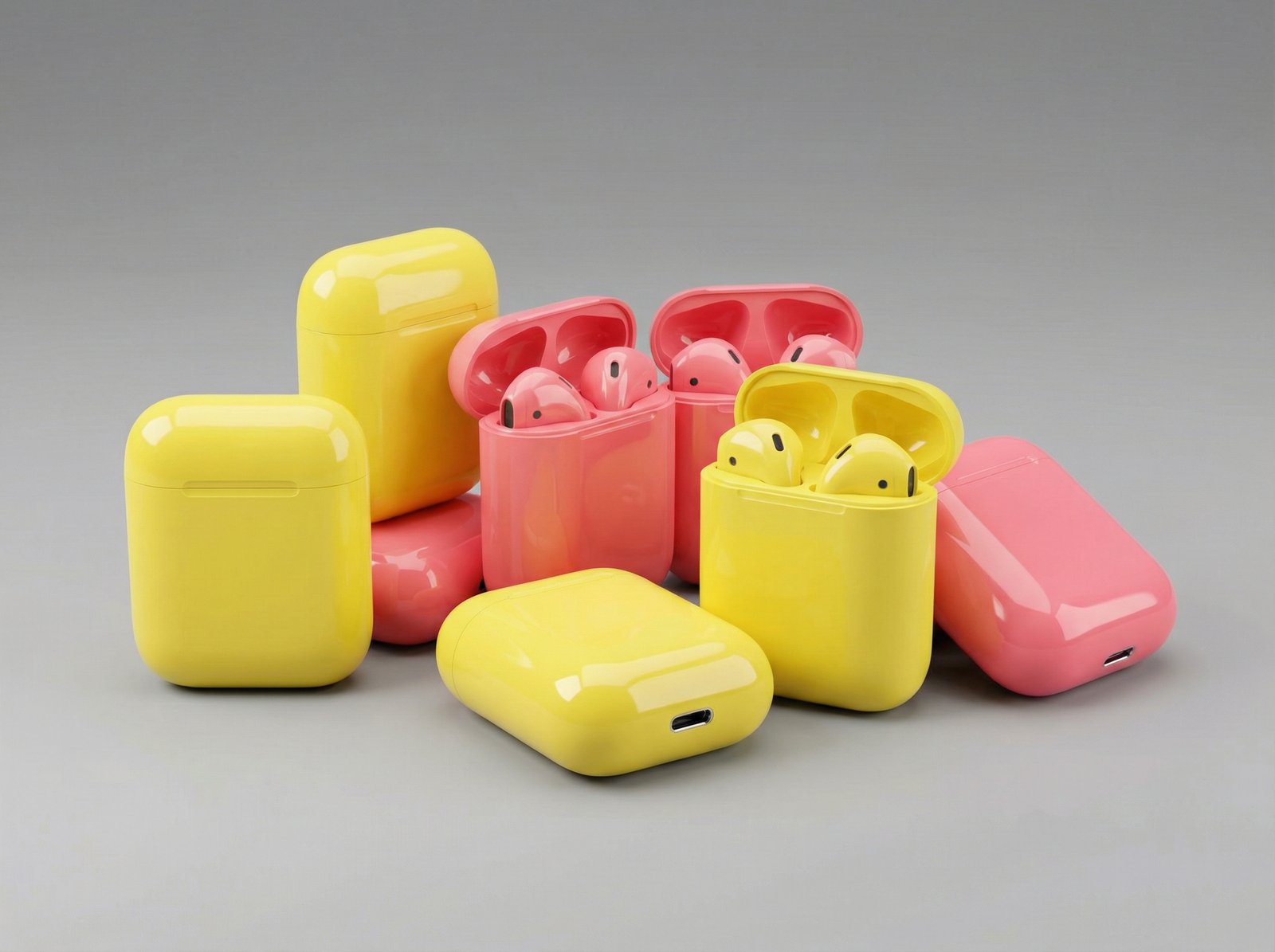 A collection of vibrant yellow and pink glossy plastic wireless earbud charging cases inspired by the iPhone 5c aesthetic, arranged on a minimalist gray surface, professional tech product photography, 4:3 aspect ratio, no text
