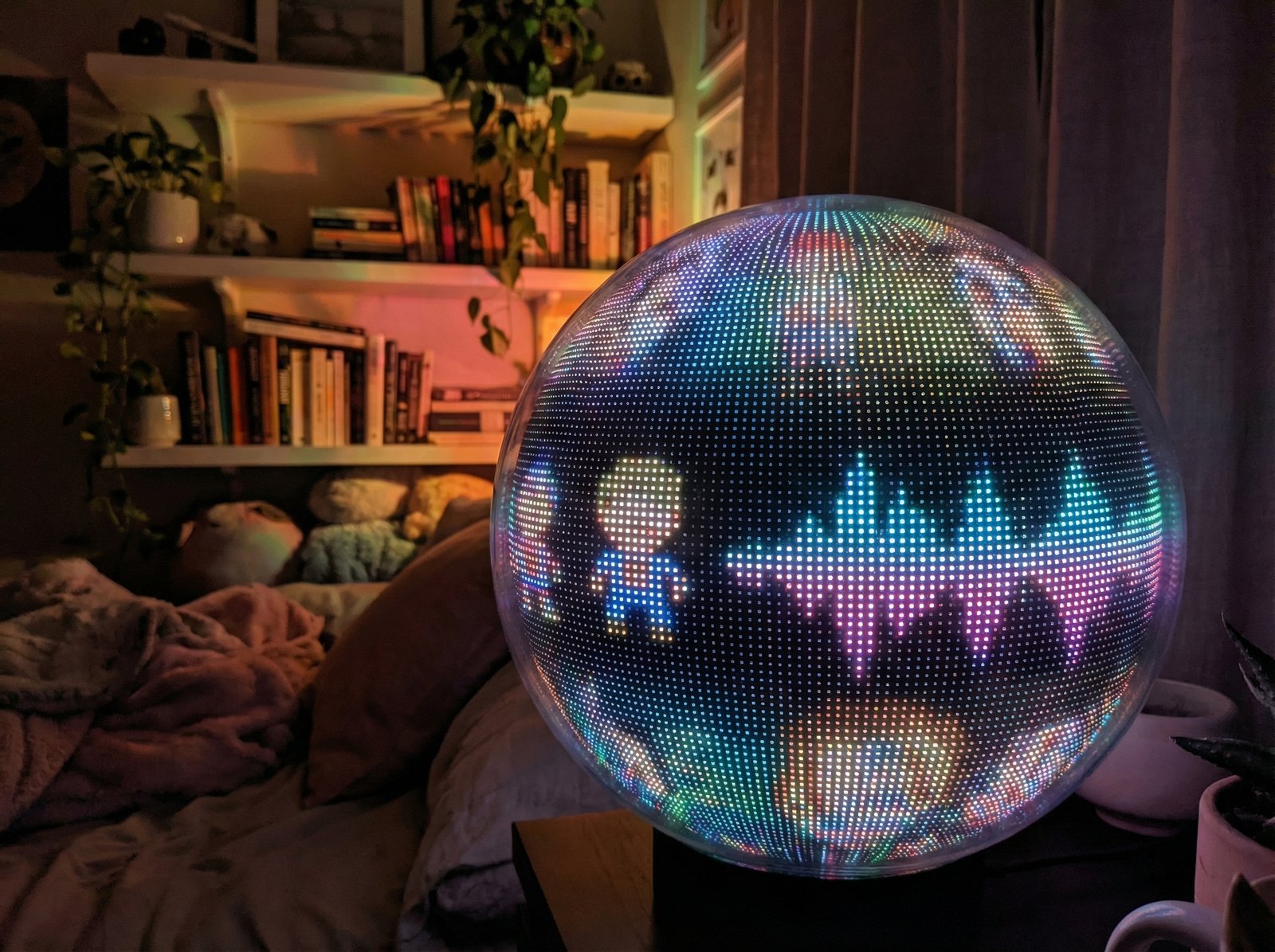 An expressive globe light named Obboto with 2,900 integrated LEDs displaying colorful pixel art and music visualization patterns in a cozy darkened bedroom, ambient glow, creative lighting, 4:3, no text.