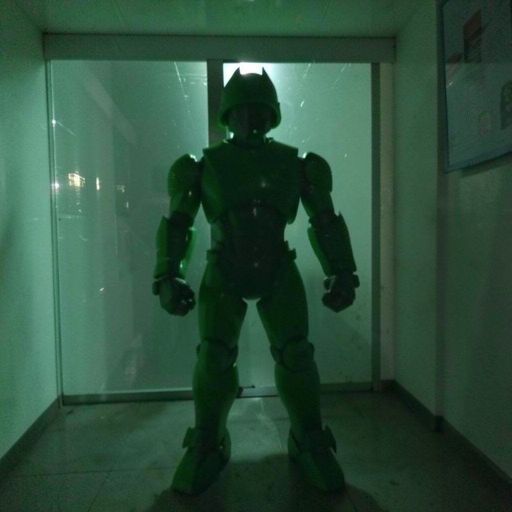 A green robot-like silhouette standing in a dim room with a glassy transparent texture, no visible text, no logos, no watermark, aspect ratio 1:1